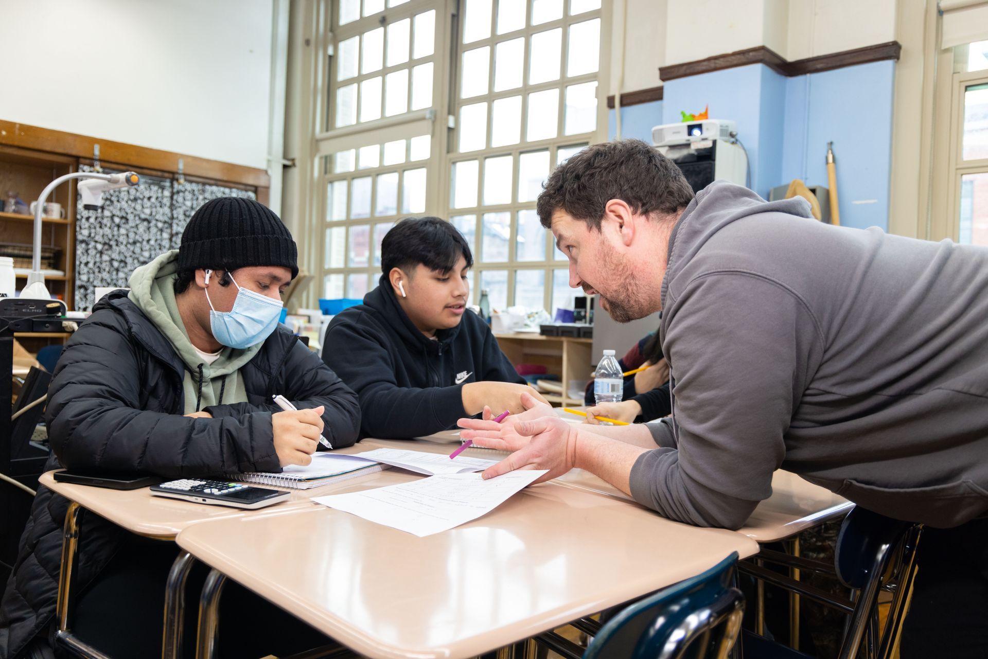 Students being helped by a teacher