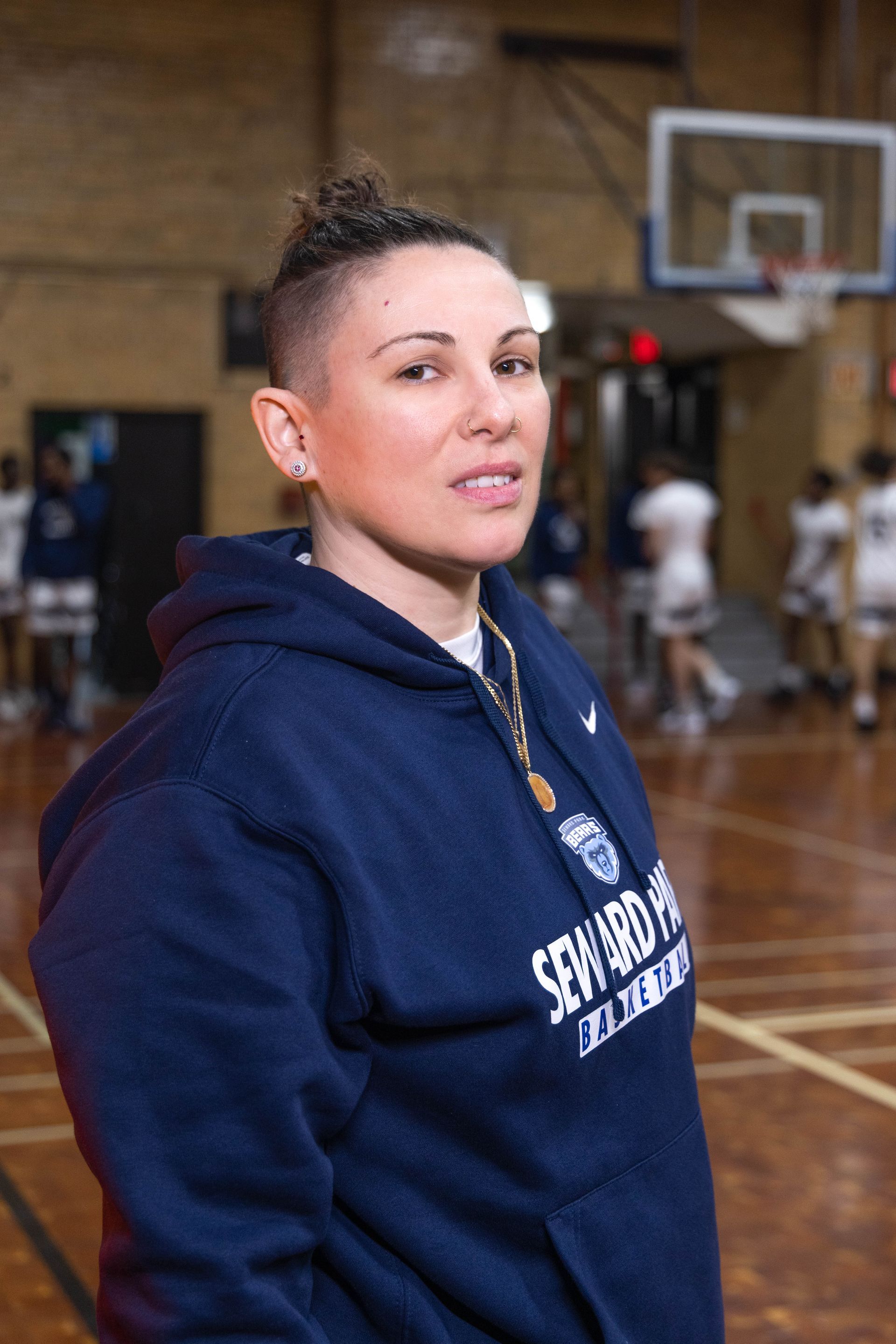 Basketball coach with student players running drills in the background