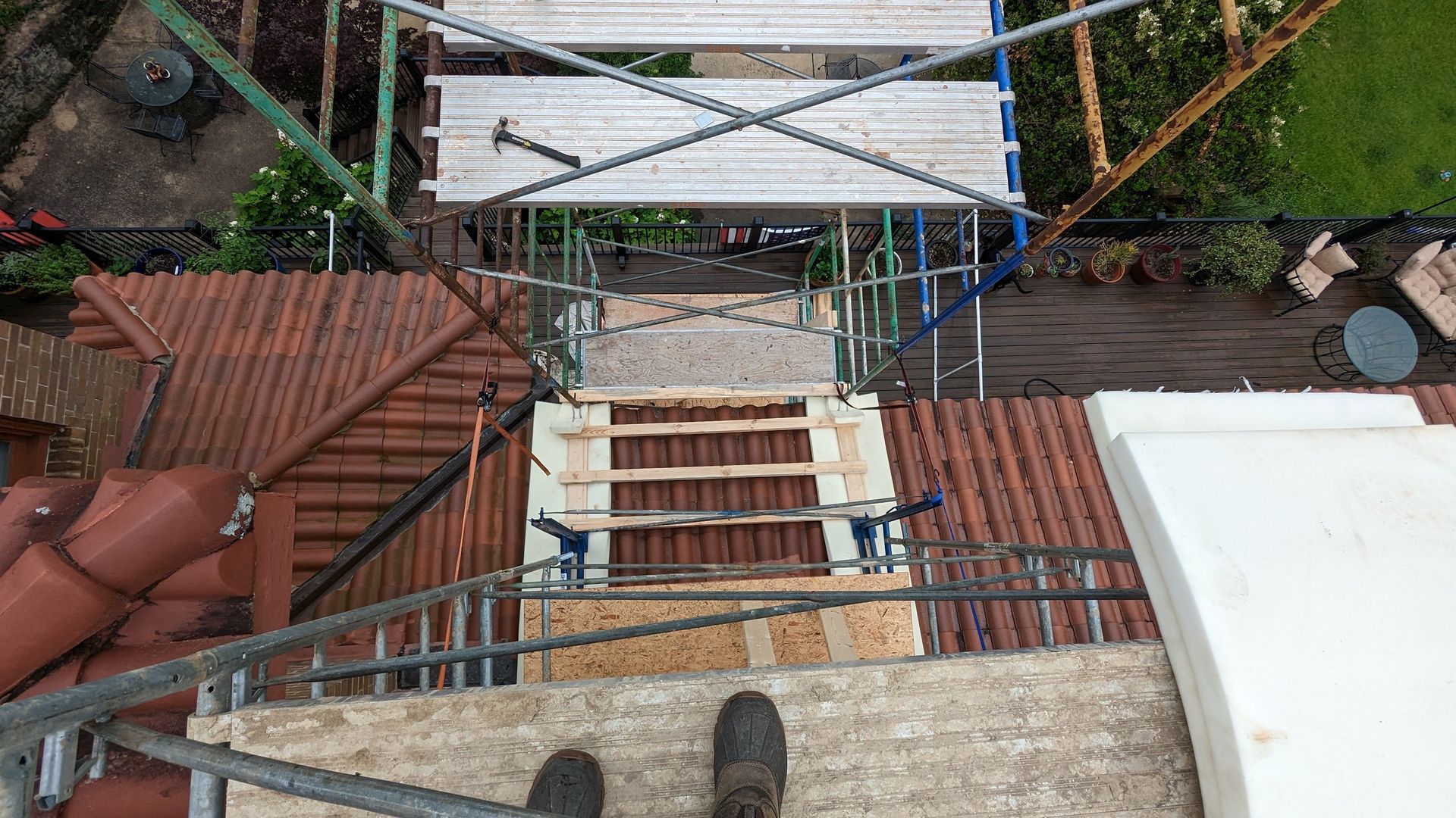 A person is standing on a ladder on top of a roof.