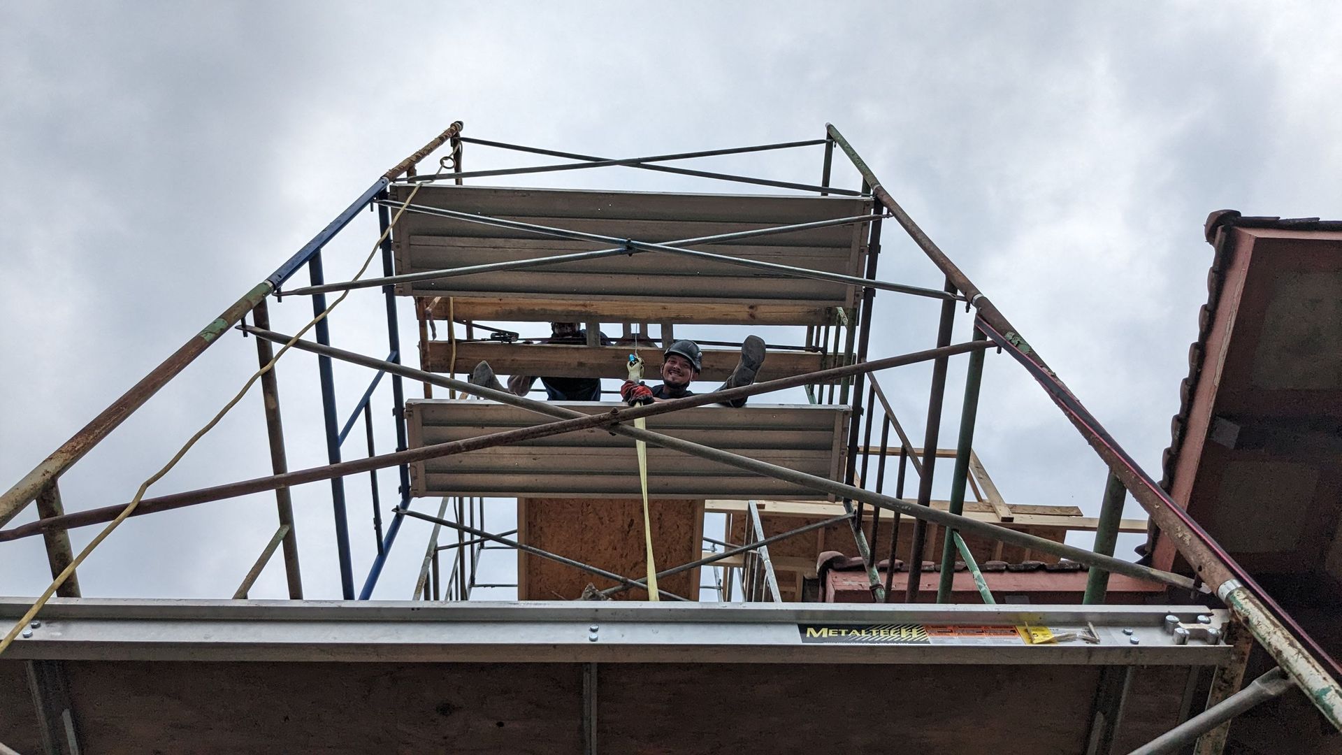 A scaffolding tower is being built on top of a building.