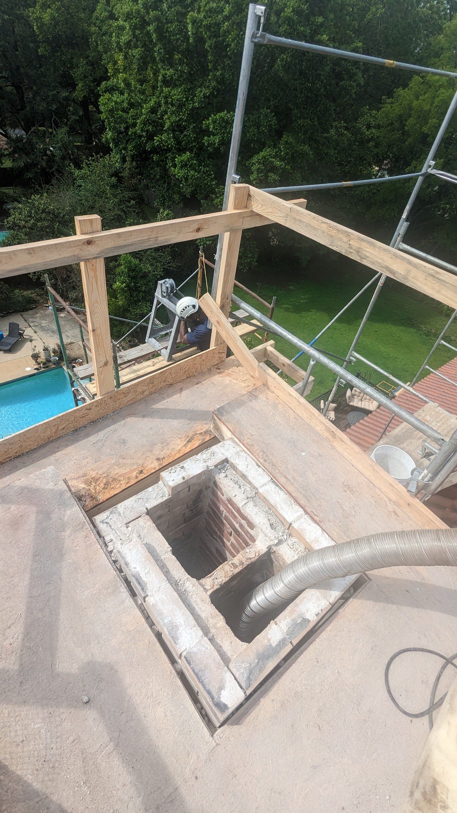 A man is working on a roof with a hose attached to it.