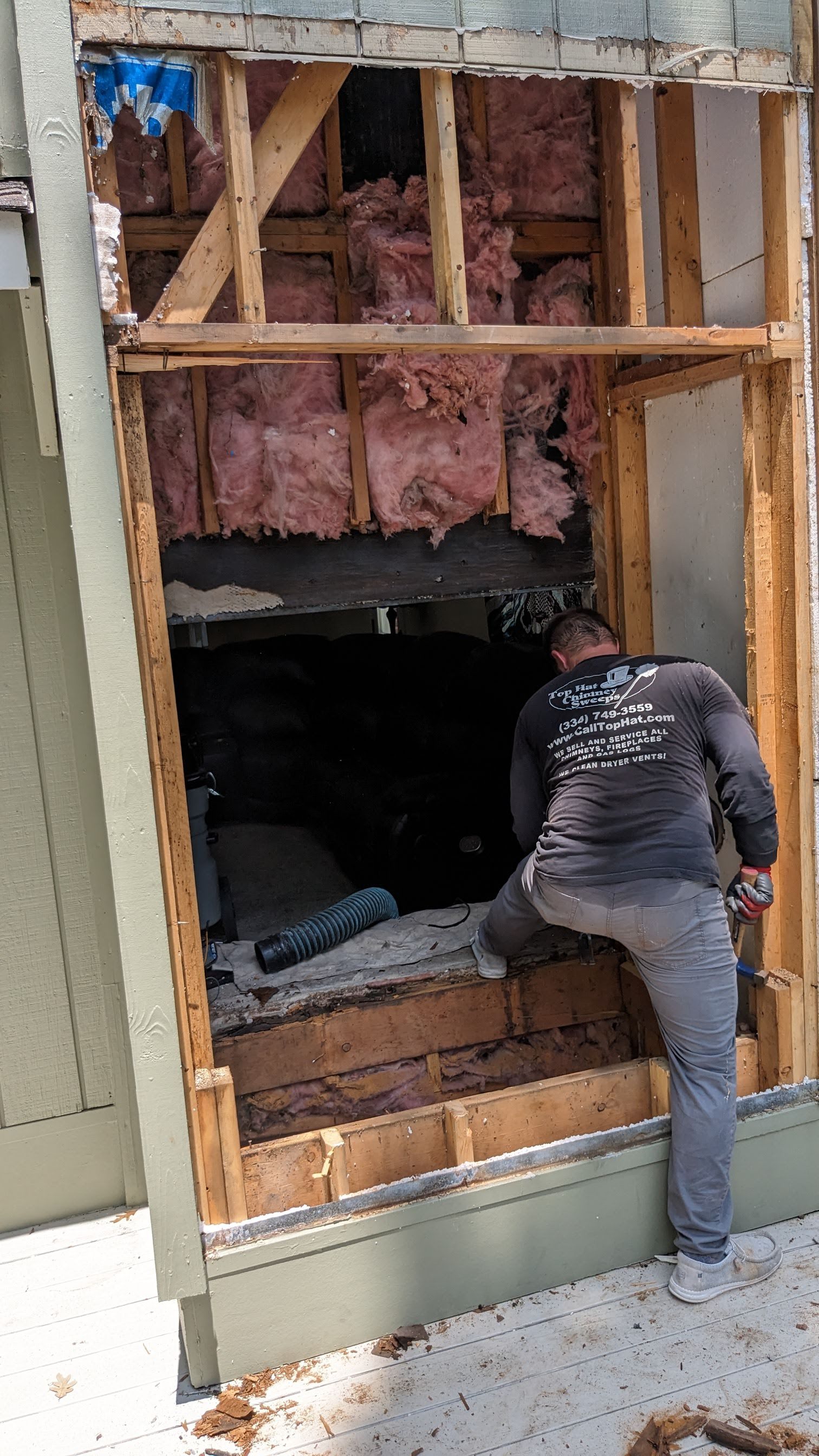 A man is standing in a hole in a wall.