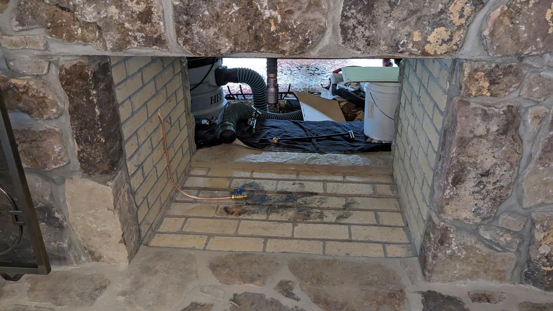 A fireplace with a brick wall and a brick floor