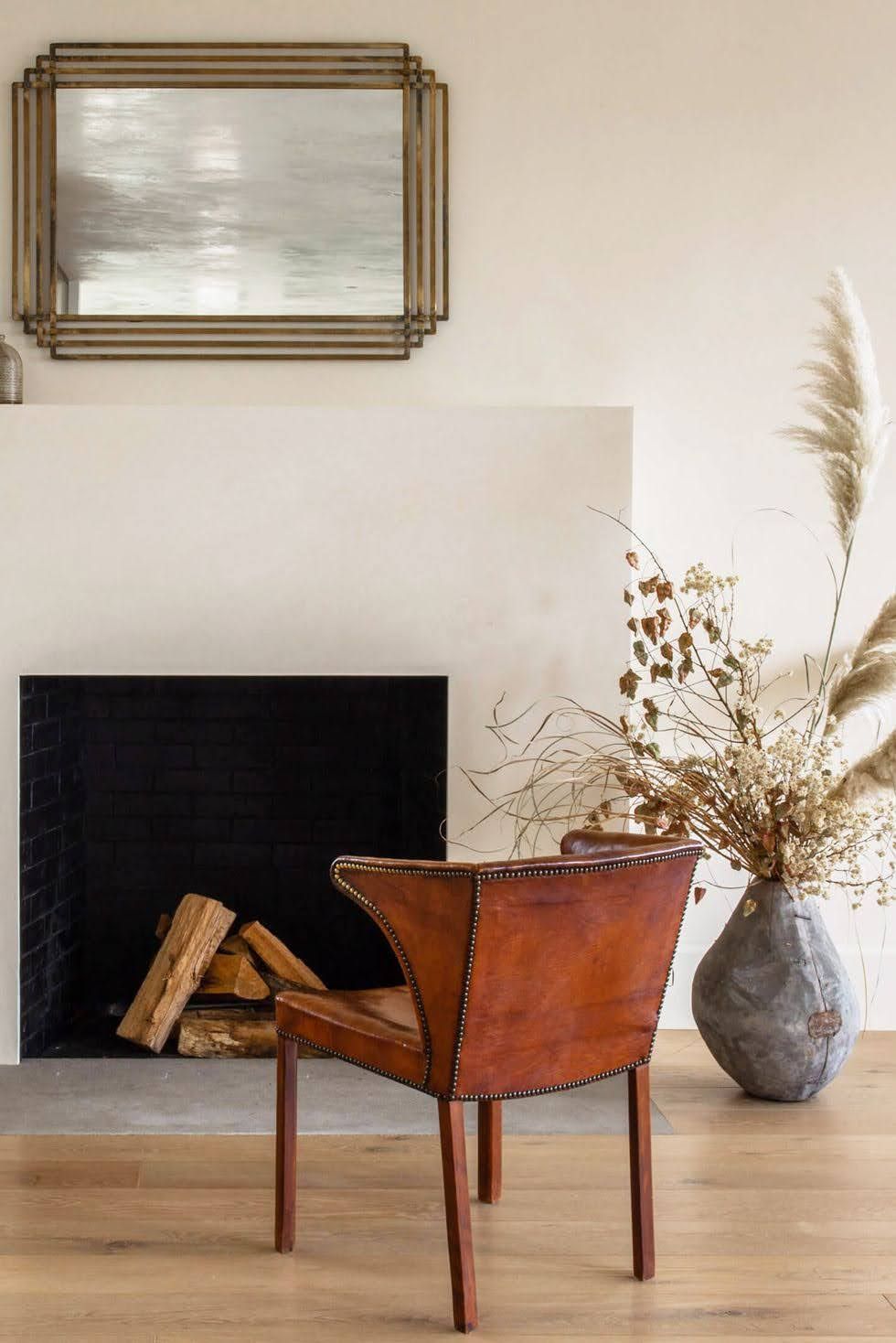 A chair is sitting in front of a fireplace in a living room.