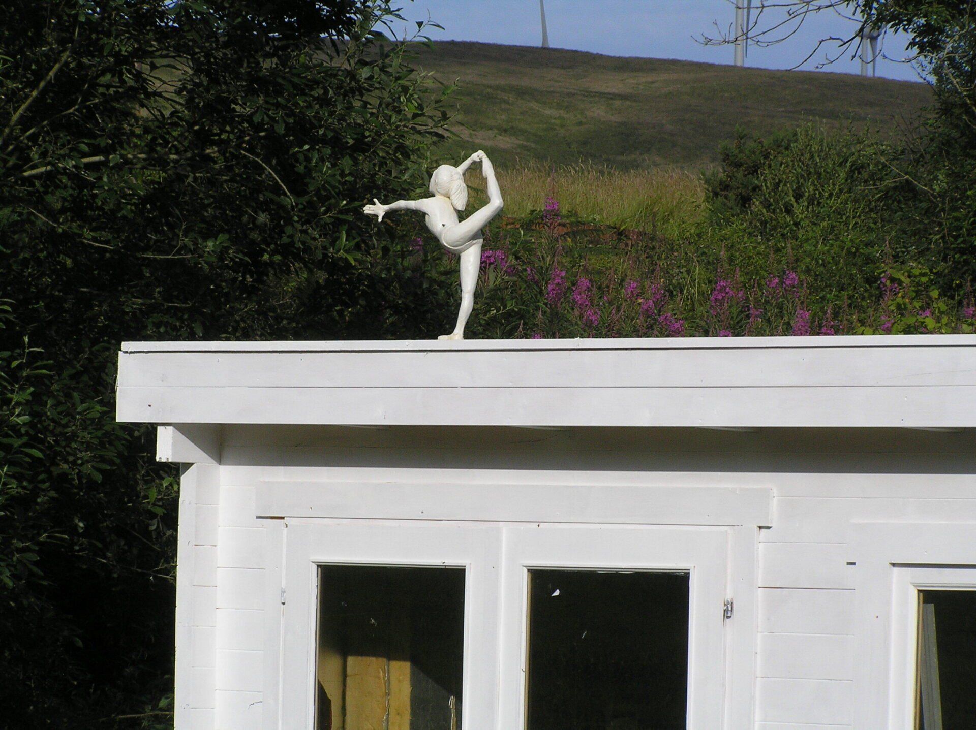 A small figurative sculpture on a garden building by Ingrained Culture 