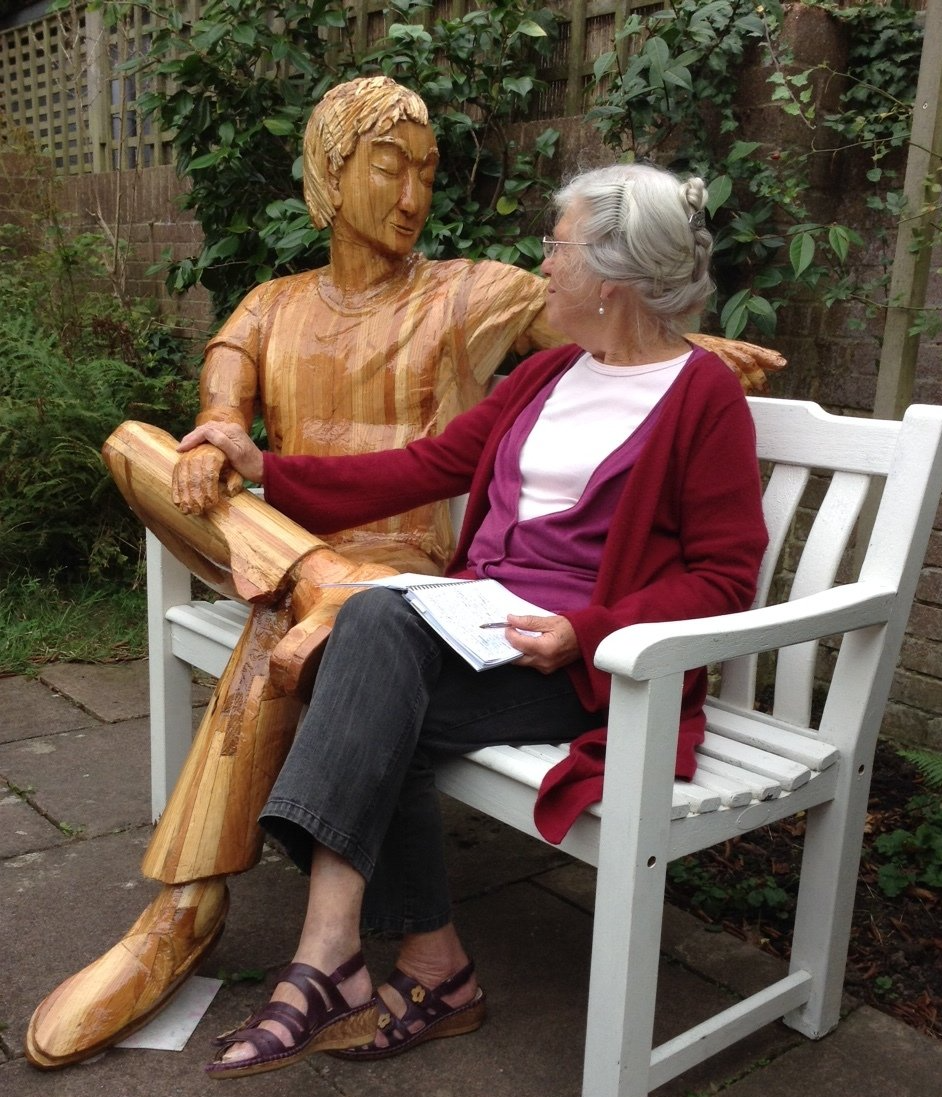A wooden figurative sculpture in use as social therapy. Made by Ingrained Culture.