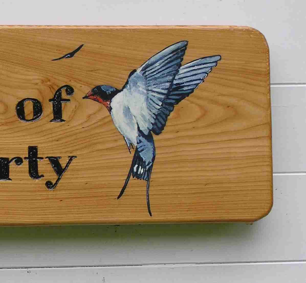 A wooden house plaque with a picture of a swallow made by Robert Ingrained Culture