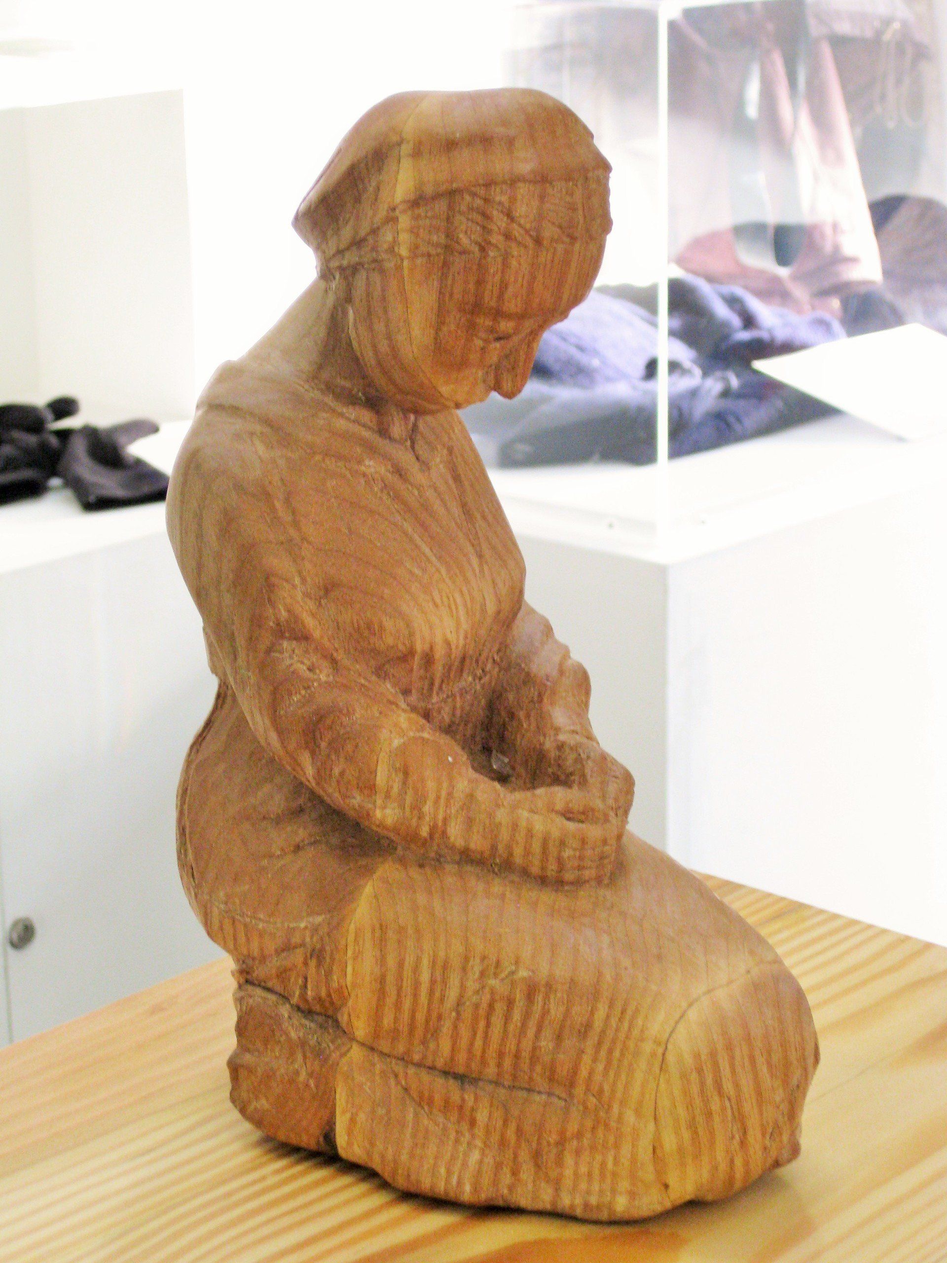 A wooden sculpture of a sad woman