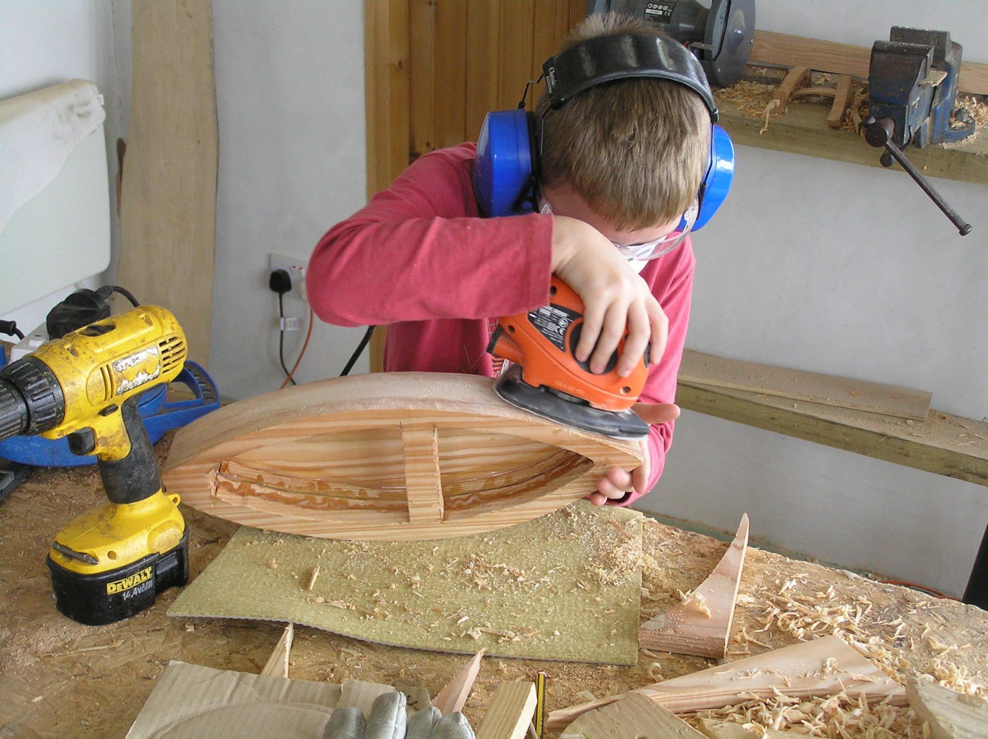 Young boy making a wooden boat