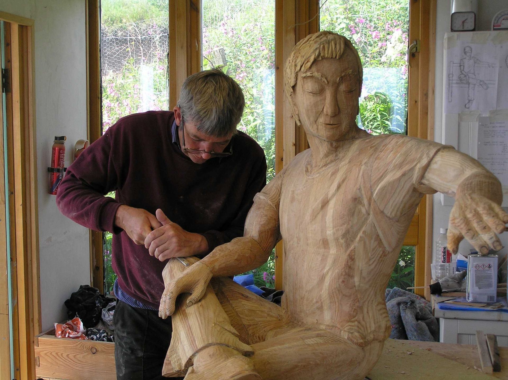 Robert the sculptor is making a wooden garden sculpture of a life size man. Made by Ingrained Culture