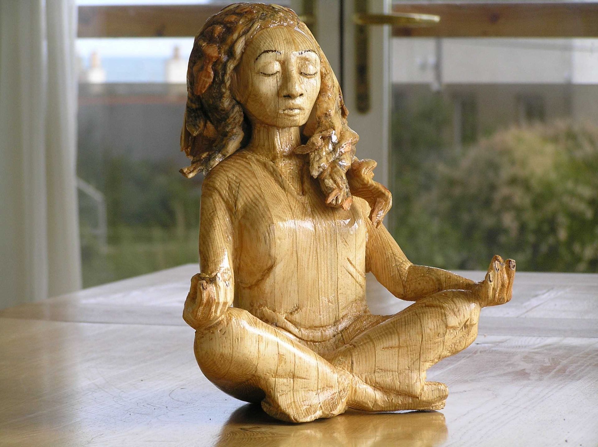 A wooden modern small scale sculpture of a black woman suitable for a table top. Made by Ingrained Culture