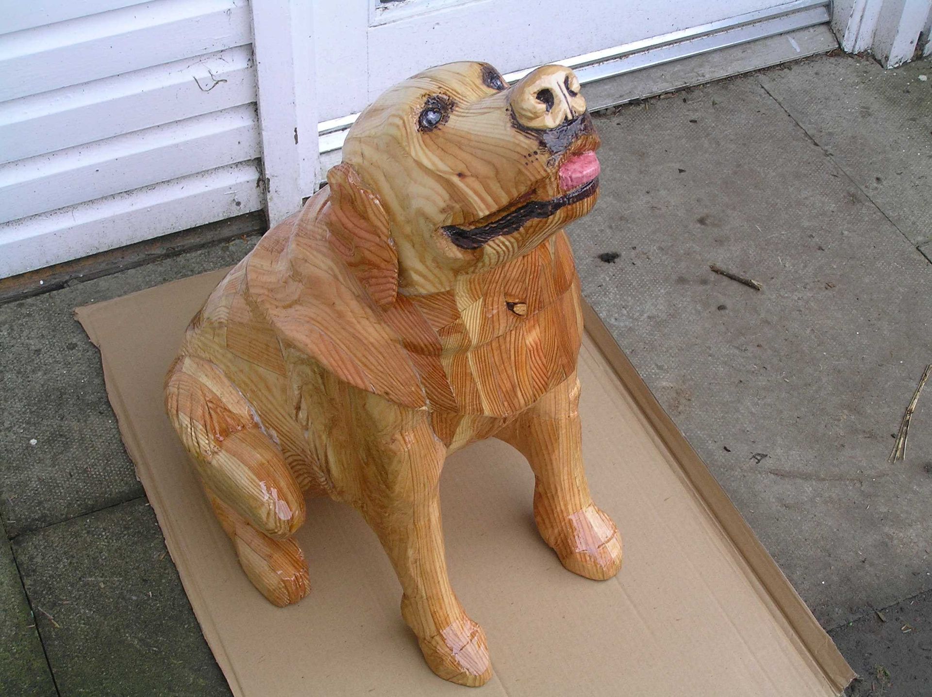 A close look at the face of a wooden dog sculpture made by Ingrained Culture