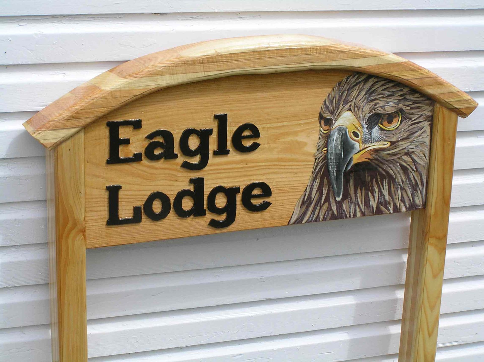 A wooden house sign with a hand painted image of an eagle's head. made by Robert of Ingrained Culture