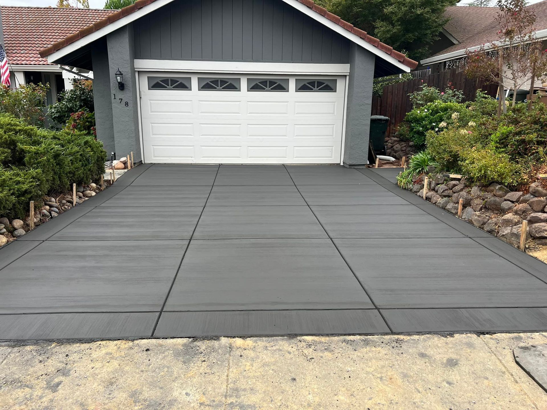 Newly poured gray concrete driveway leading to a two-car garage.