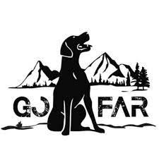 a black and white silhouette of a dog sitting in front of mountains .