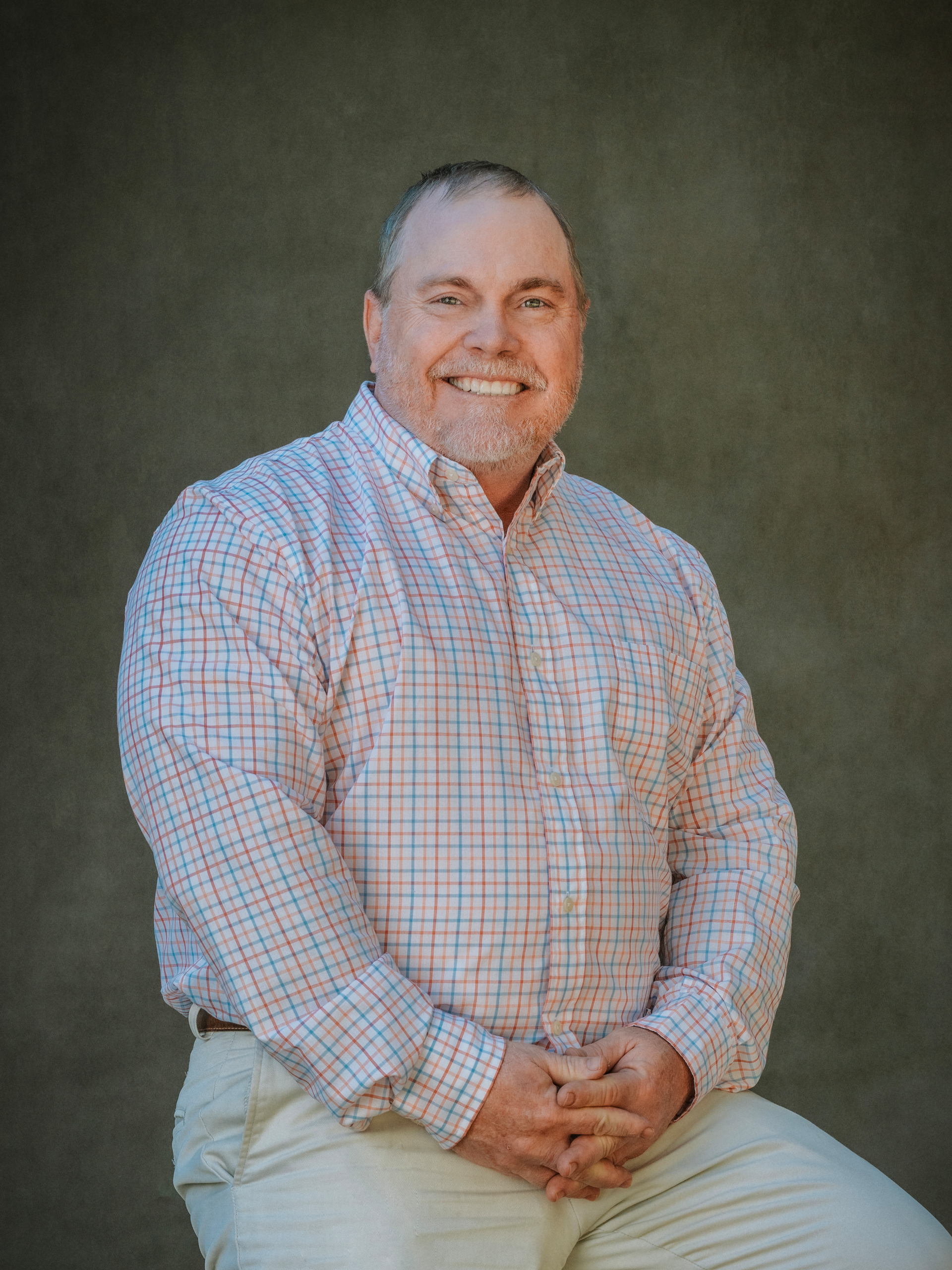 Randy Casey is wearing a white shirt and smiling for the camera.