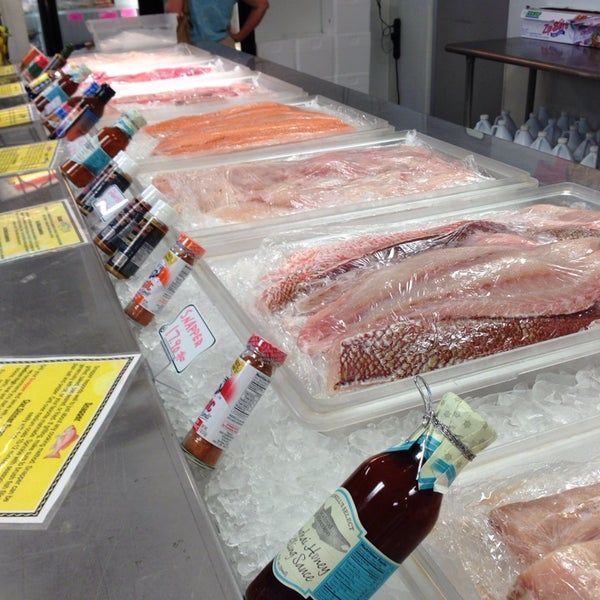 sliced fish wrapped in plastic placed on top of ice at a market