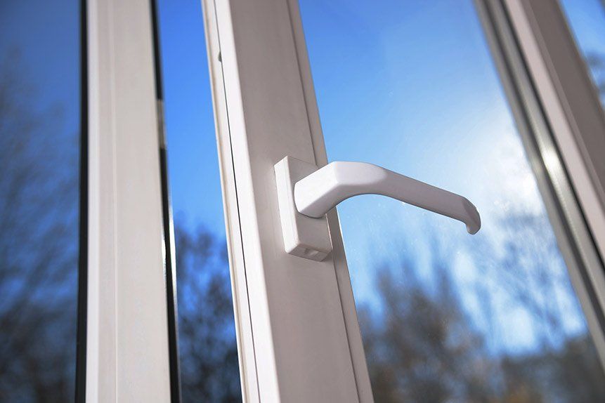 A close up of an open window with a white handle.