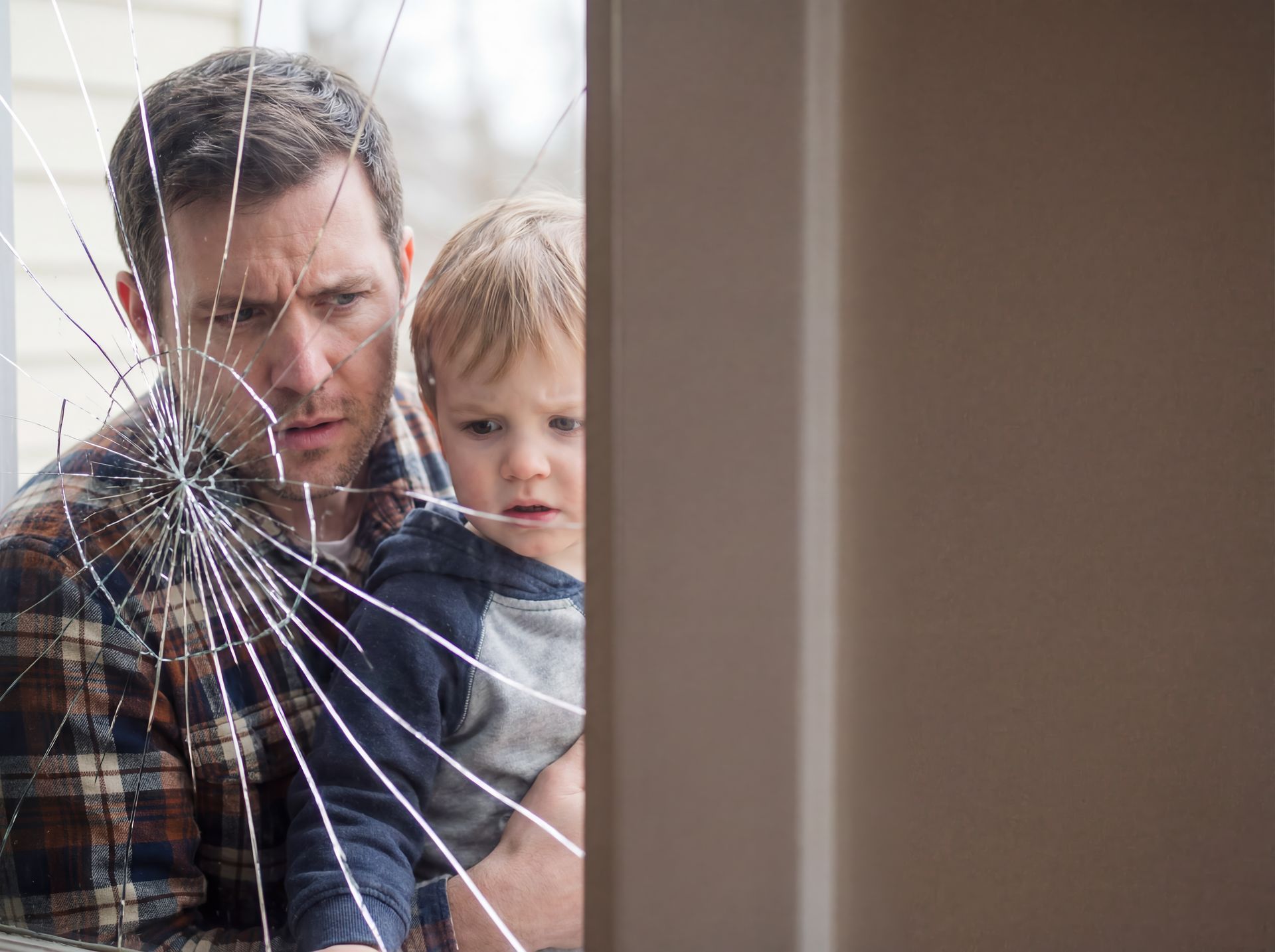 Shattered window pane with family needing an emergency residential glass repair service.