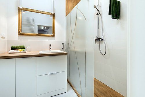 A bathroom with a sink , mirror and shower.