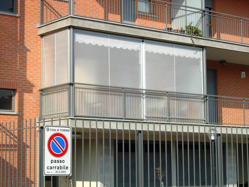 Zoom sulle tende invernali a Torino trasparenti sul balcone di un appartamento
