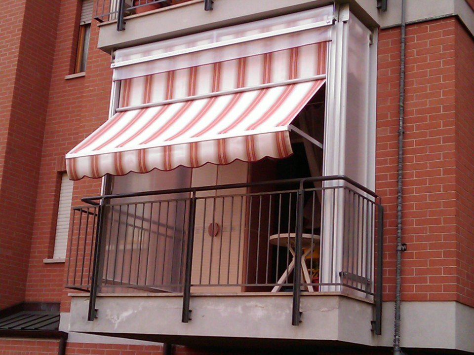 Tenda estiva rossa e bianca a righe su un balcone