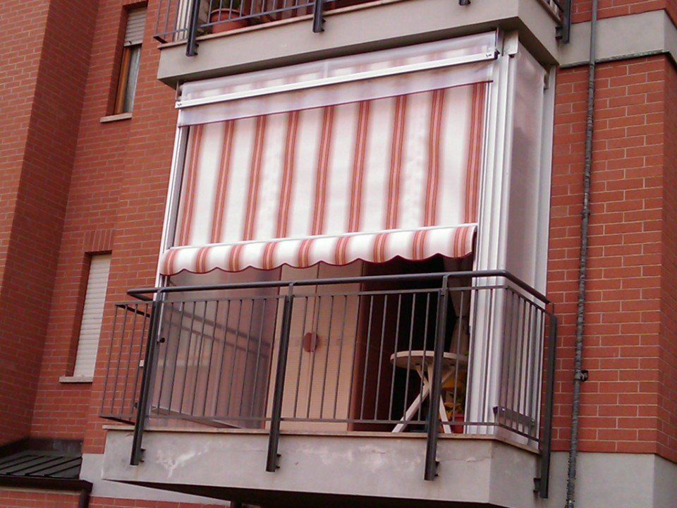 Tenda estiva a righe bianche e rosse su un balcone a Torino