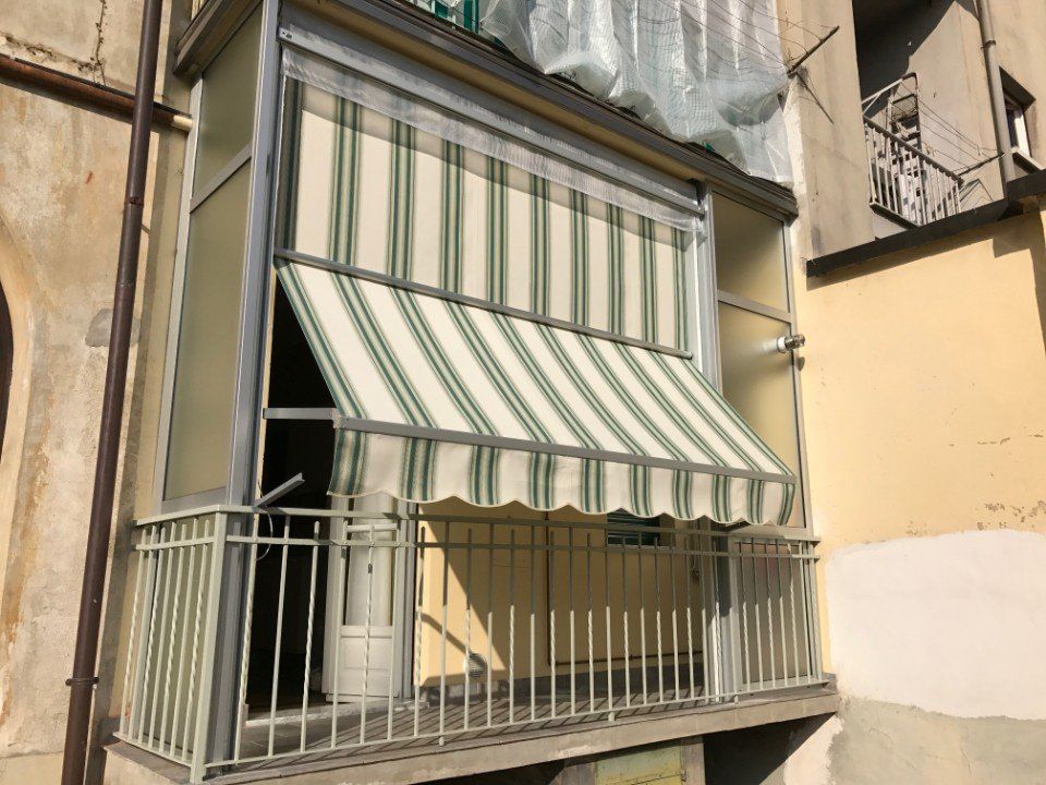 Tende veranda a Torino a righe bianche e verdi su un balcone