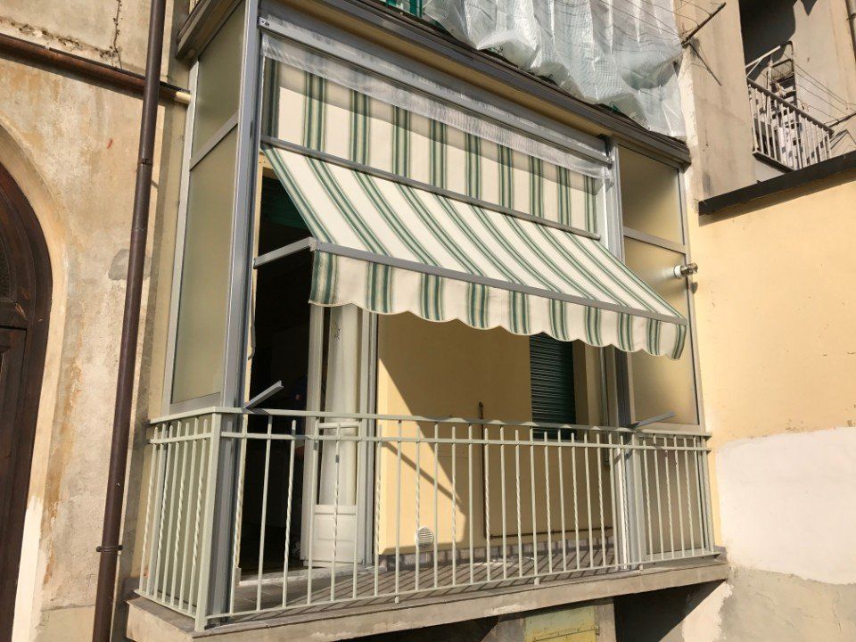 Tenda estiva su balcone a righe bianche e verdi chiusa