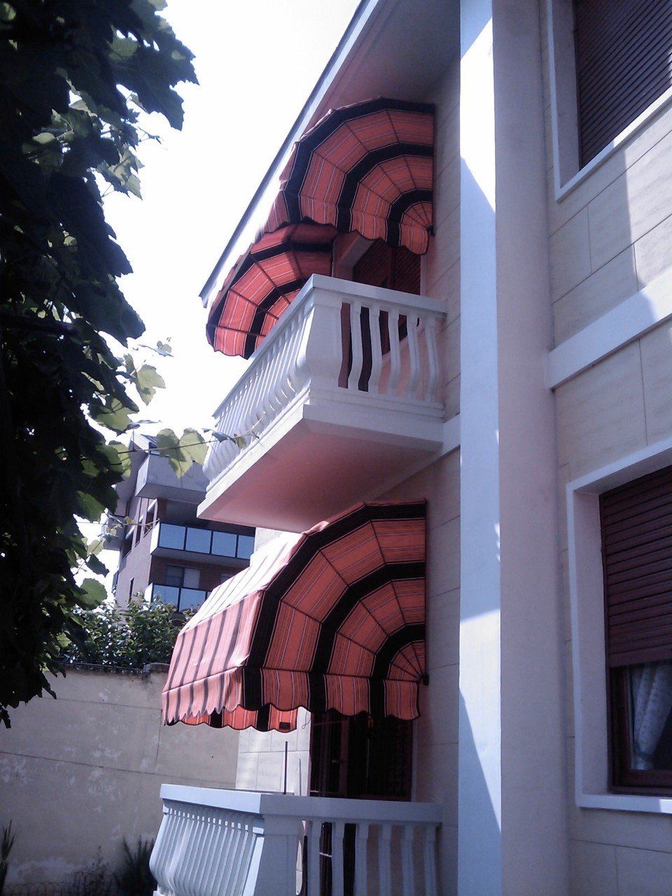 Edificio con tende a capote coordinate