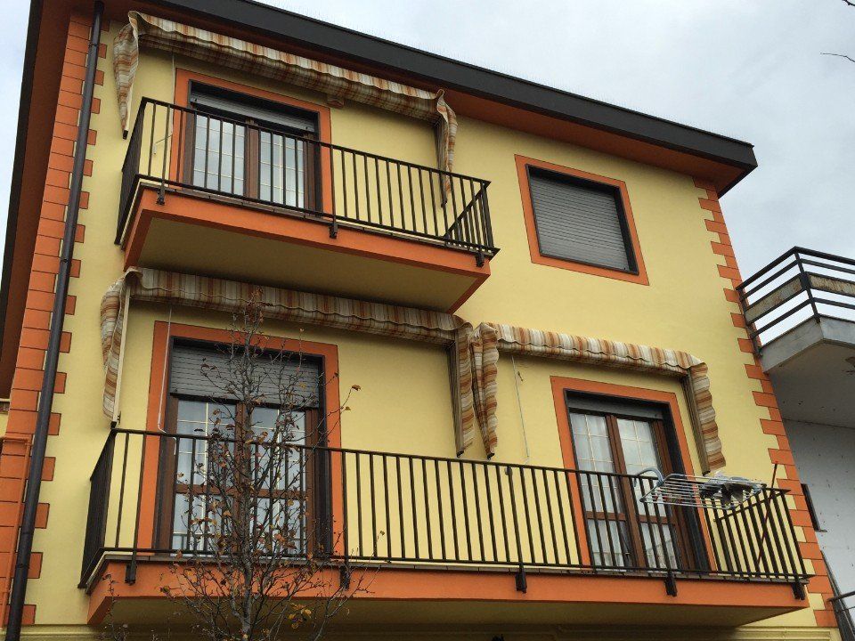 Palazzo giallo con tende a capote