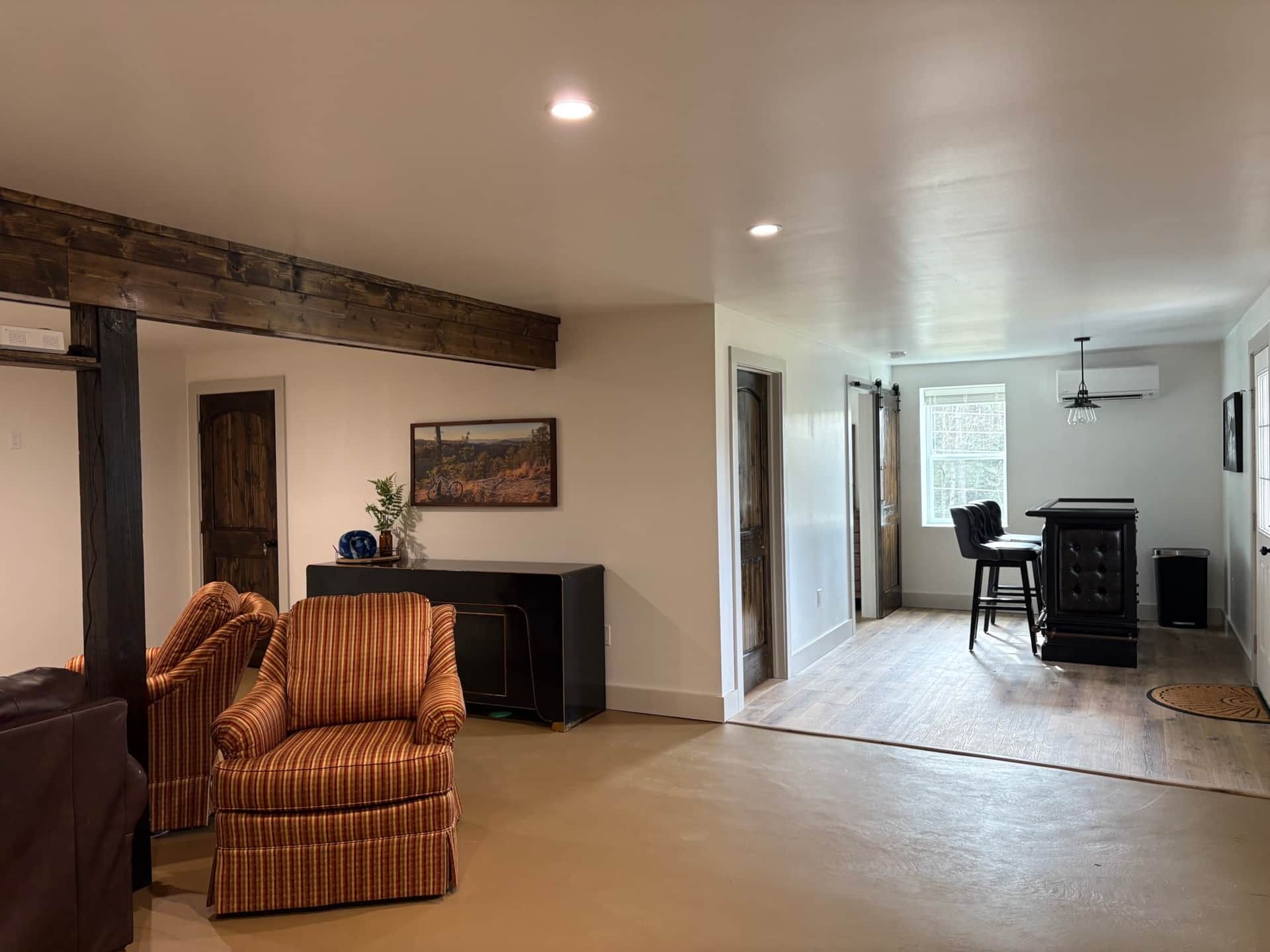 A living room with two chairs , a table and a bar.