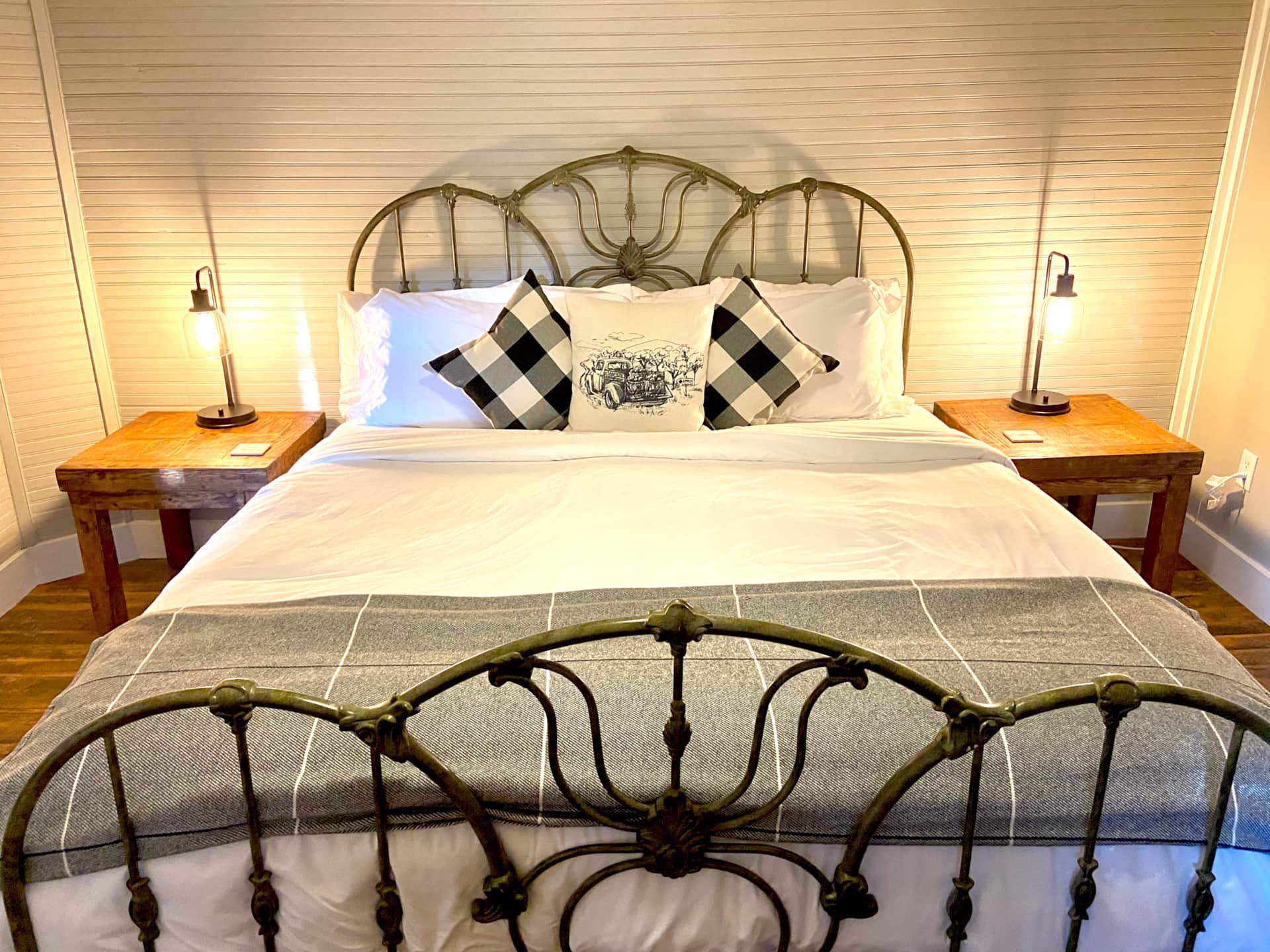 A bedroom with a bed , two nightstands and two lamps.