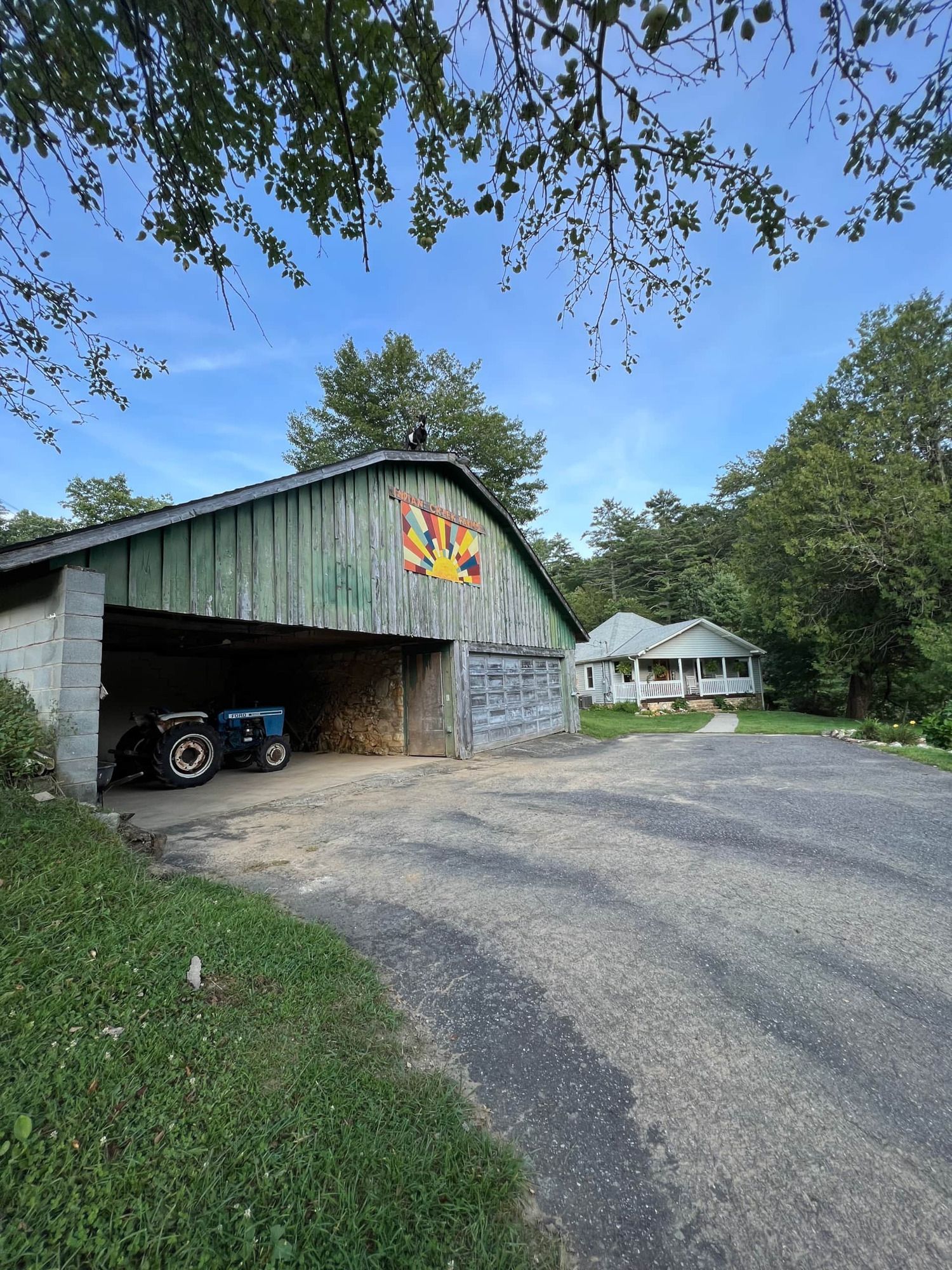 A barn with a tractor parked inside of it.