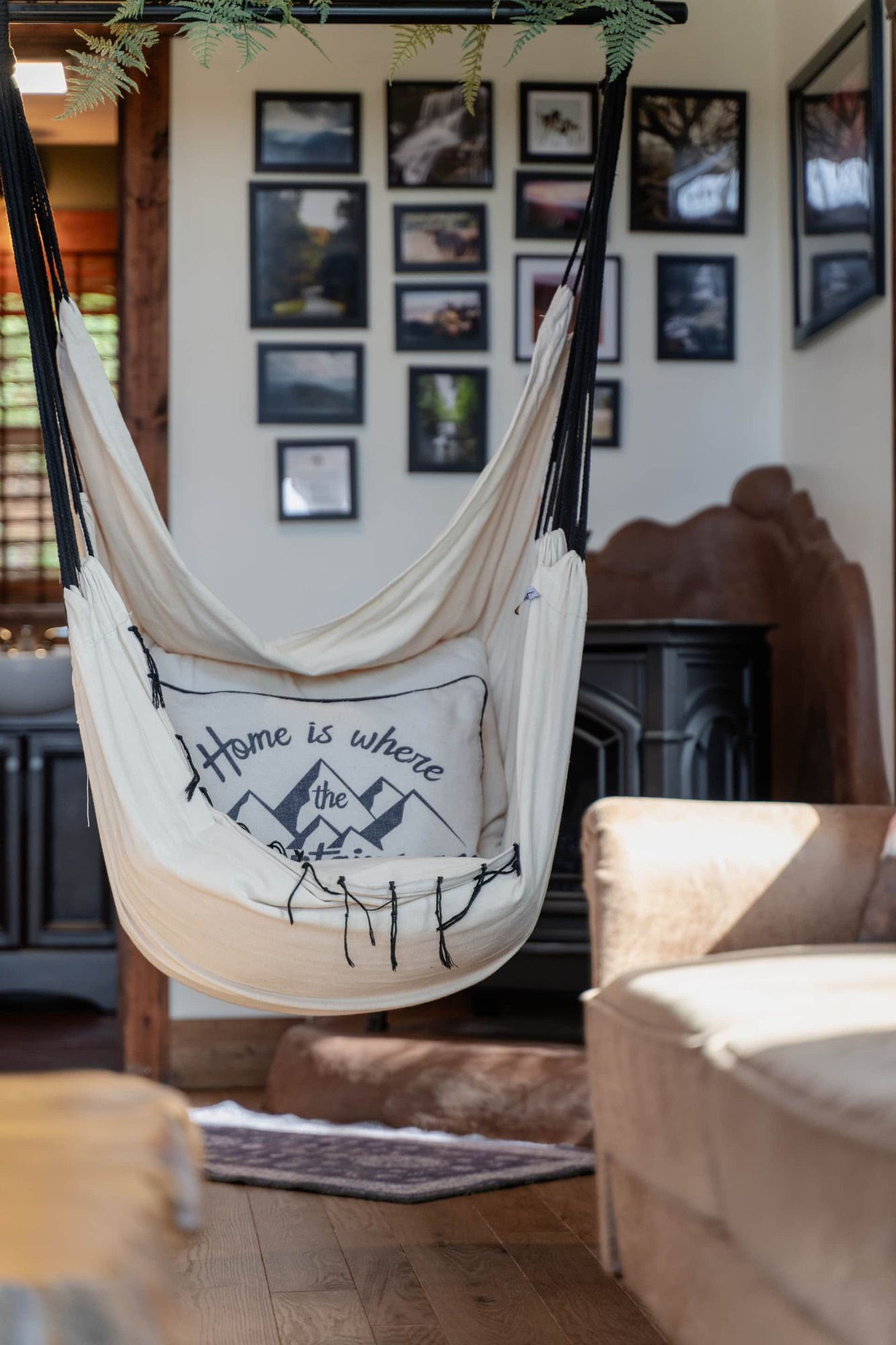 A hammock is hanging from the ceiling in a living room.