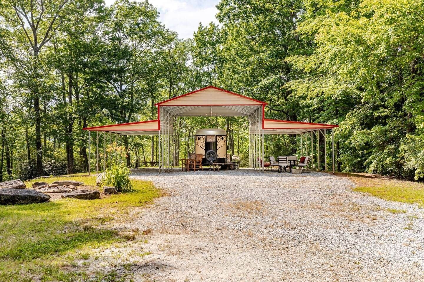 There is a rv parked under a canopy in the middle of the woods.