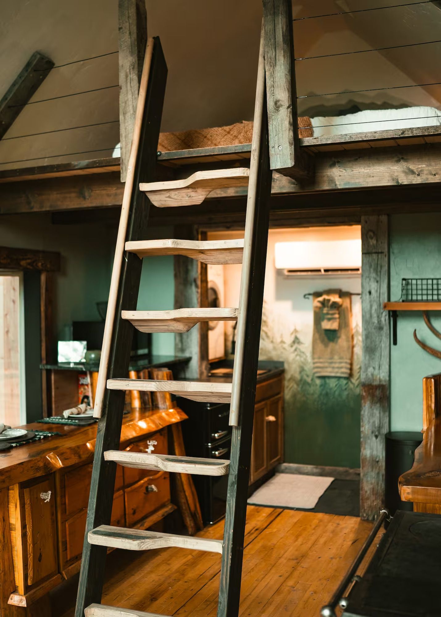 A wooden ladder leading up to a loft in a house.