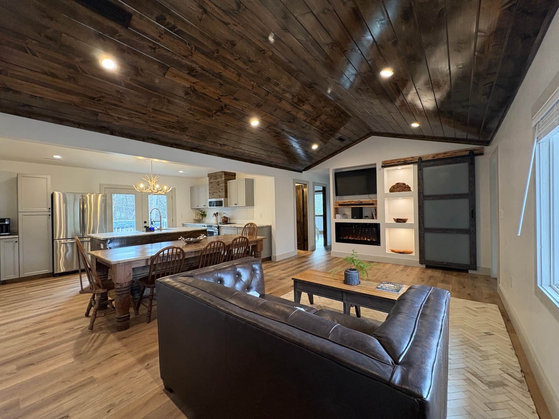 A living room filled with furniture and a wooden ceiling.