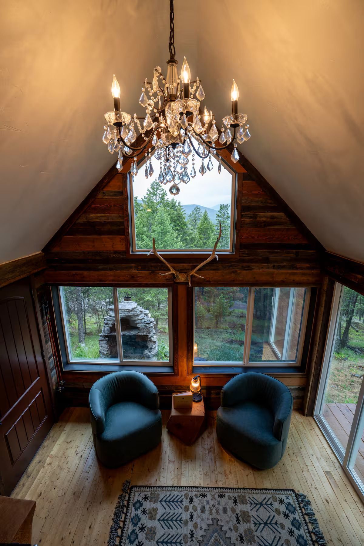A living room with two chairs and a chandelier hanging from the ceiling.