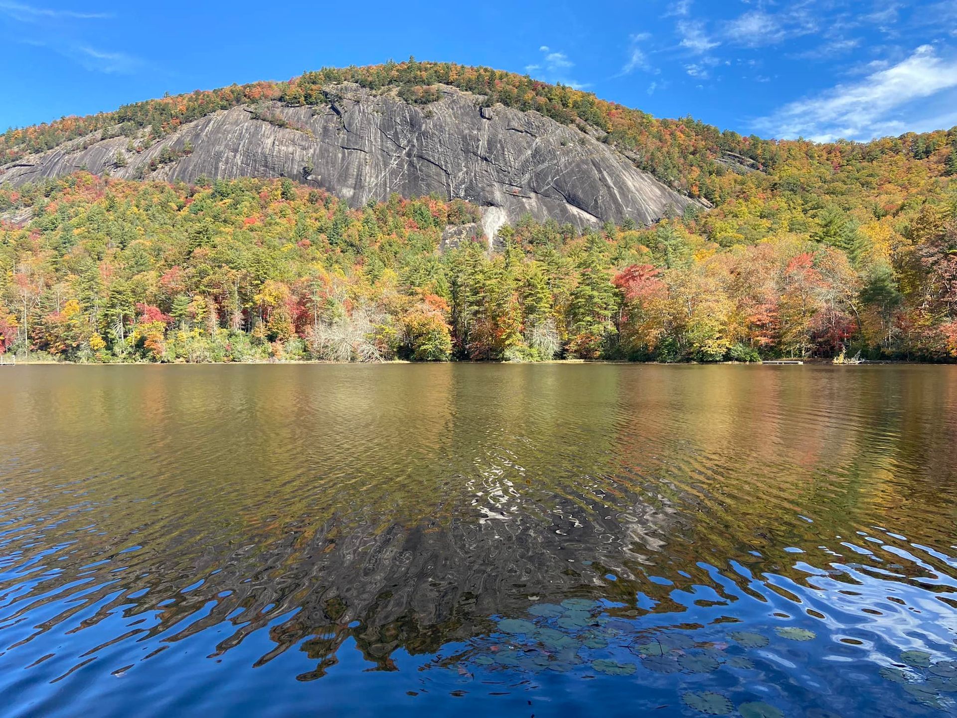 A lake with a mountain in the background and trees on the shore.