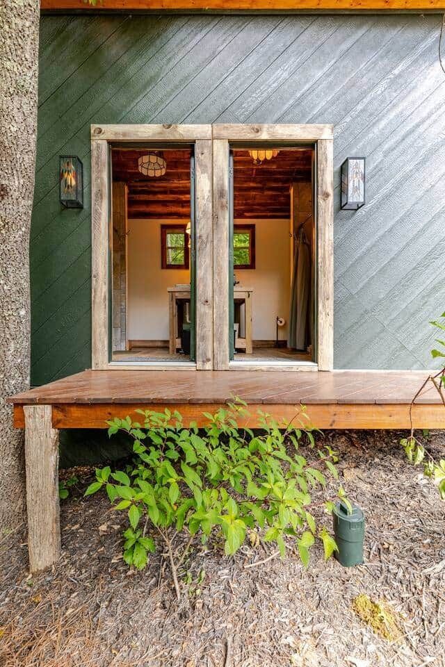 A small house with a wooden deck and sliding glass doors.