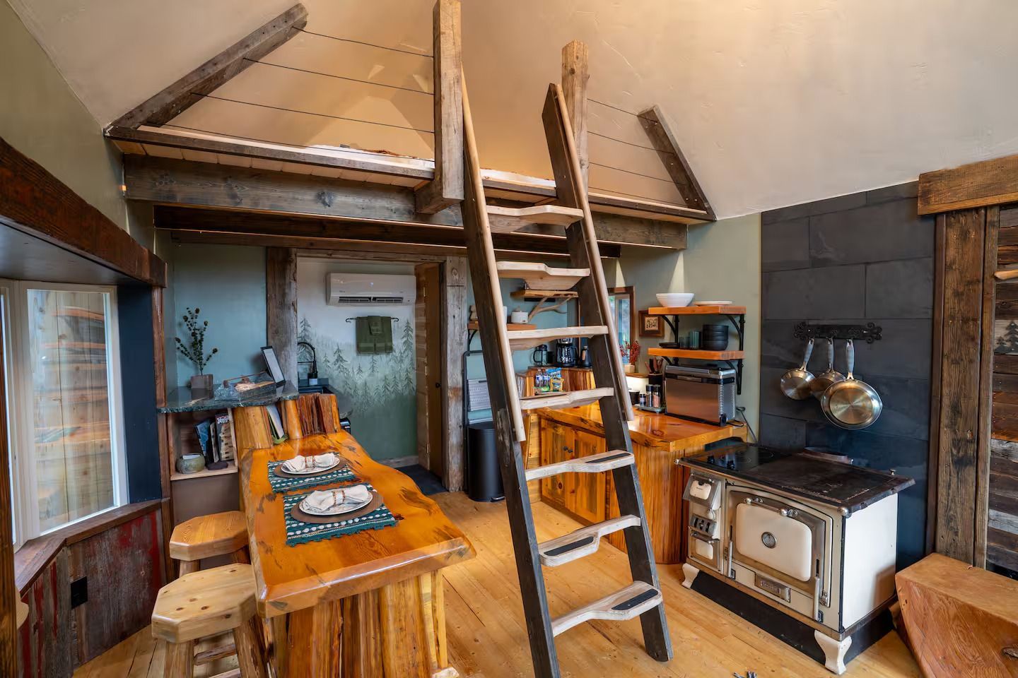 A kitchen with a ladder leading up to the second floor.