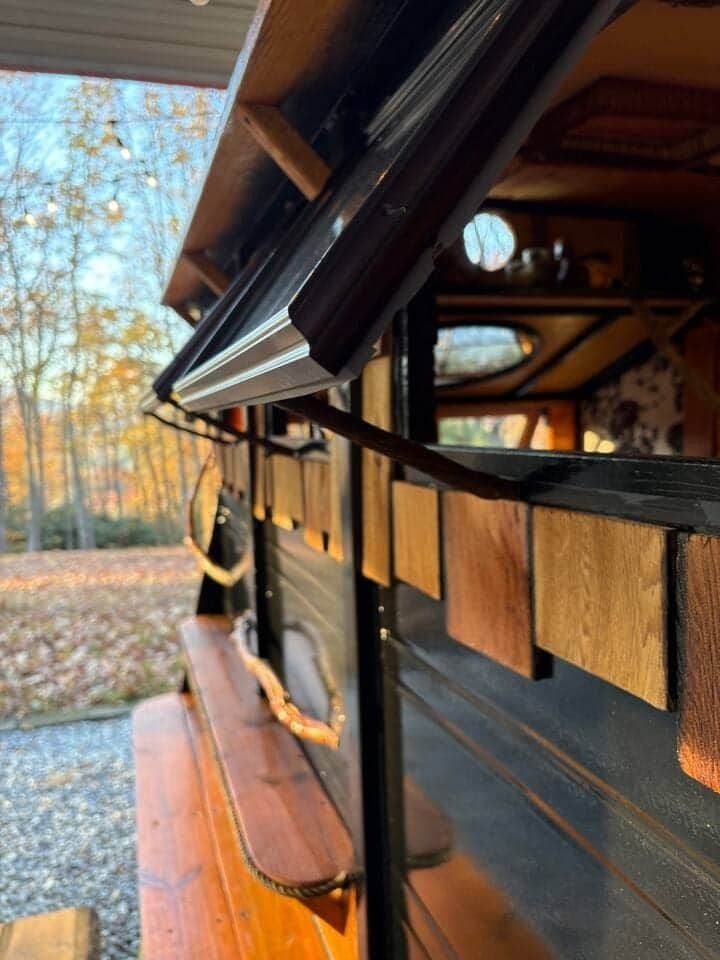 A close up of a wooden bench on the side of a building.