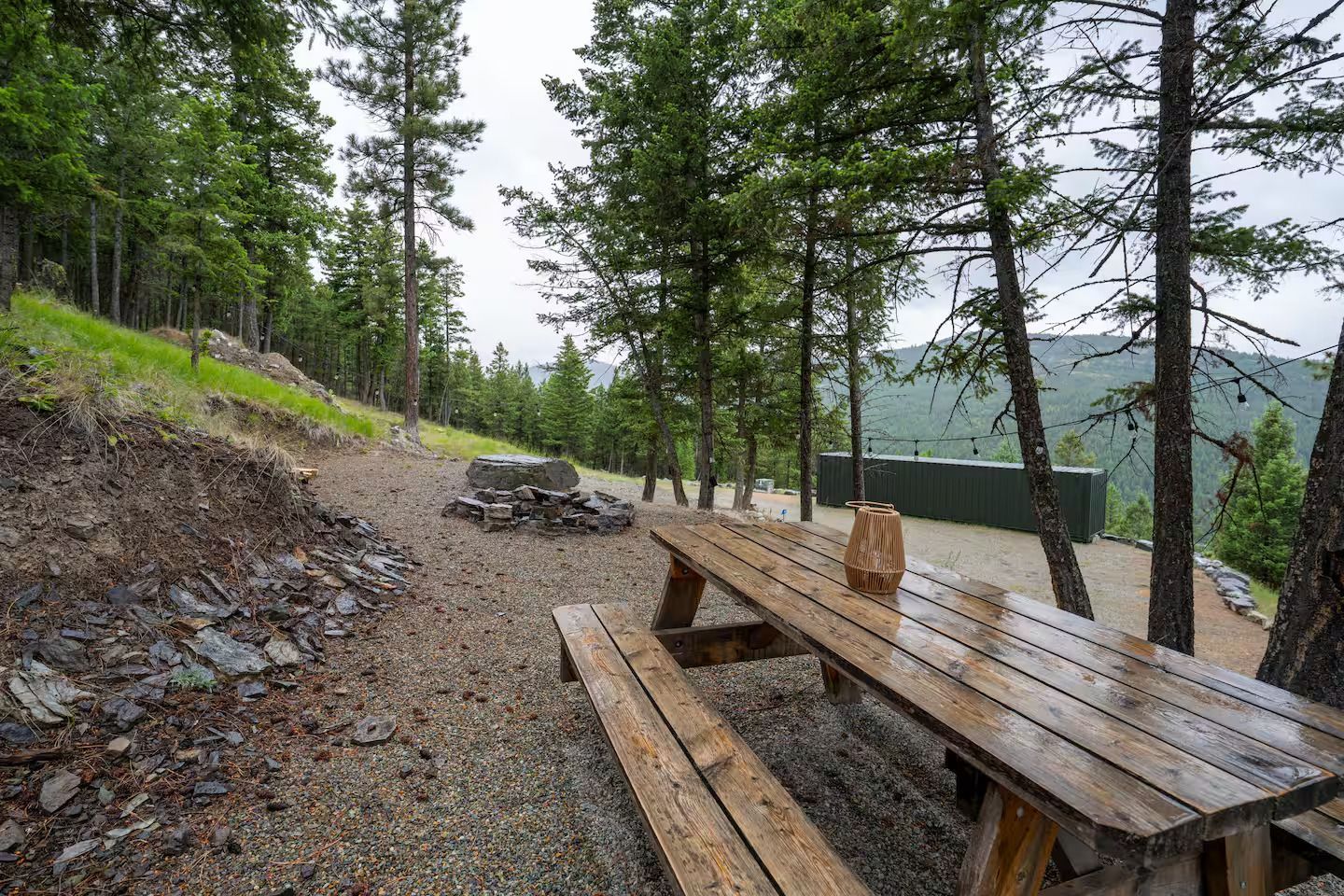 A wooden picnic table is sitting in the middle of a forest.