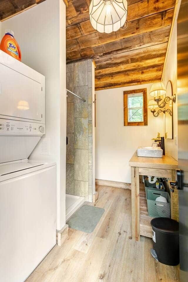 A bathroom with a washer and dryer and a sink.