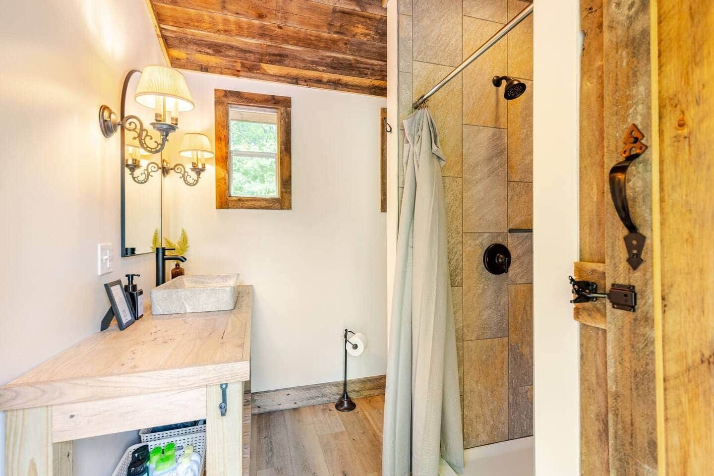 A bathroom with a sink , mirror , and shower.