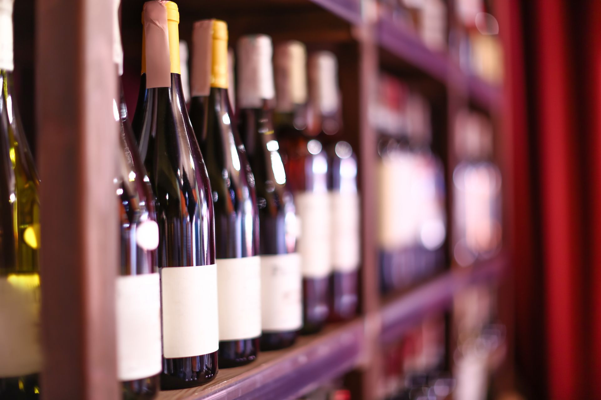 A row of wine bottles sitting on a shelf in a wine cellar.