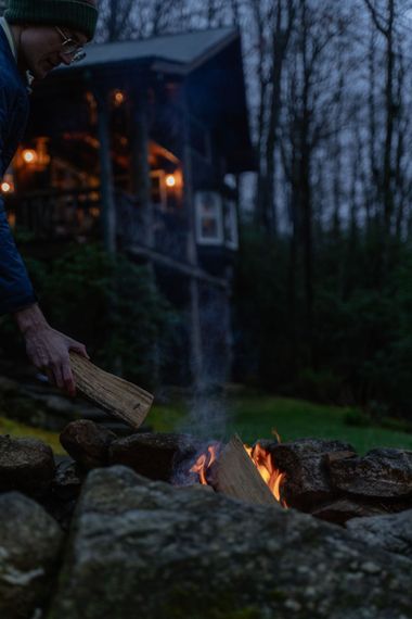 There is a porch with a wooden railing and a yellow door.