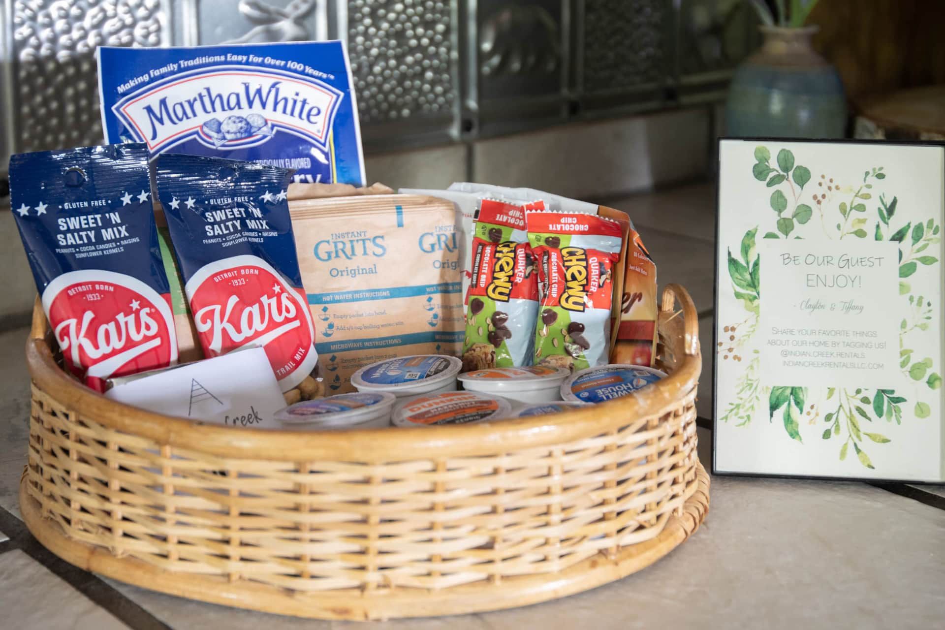 A wicker basket filled with snacks and a welcome sign.