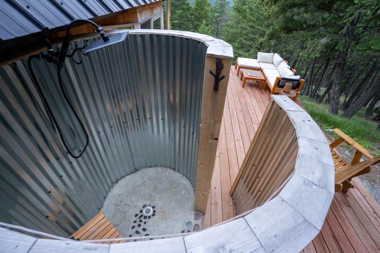 A circular outdoor shower with a wooden deck in the background